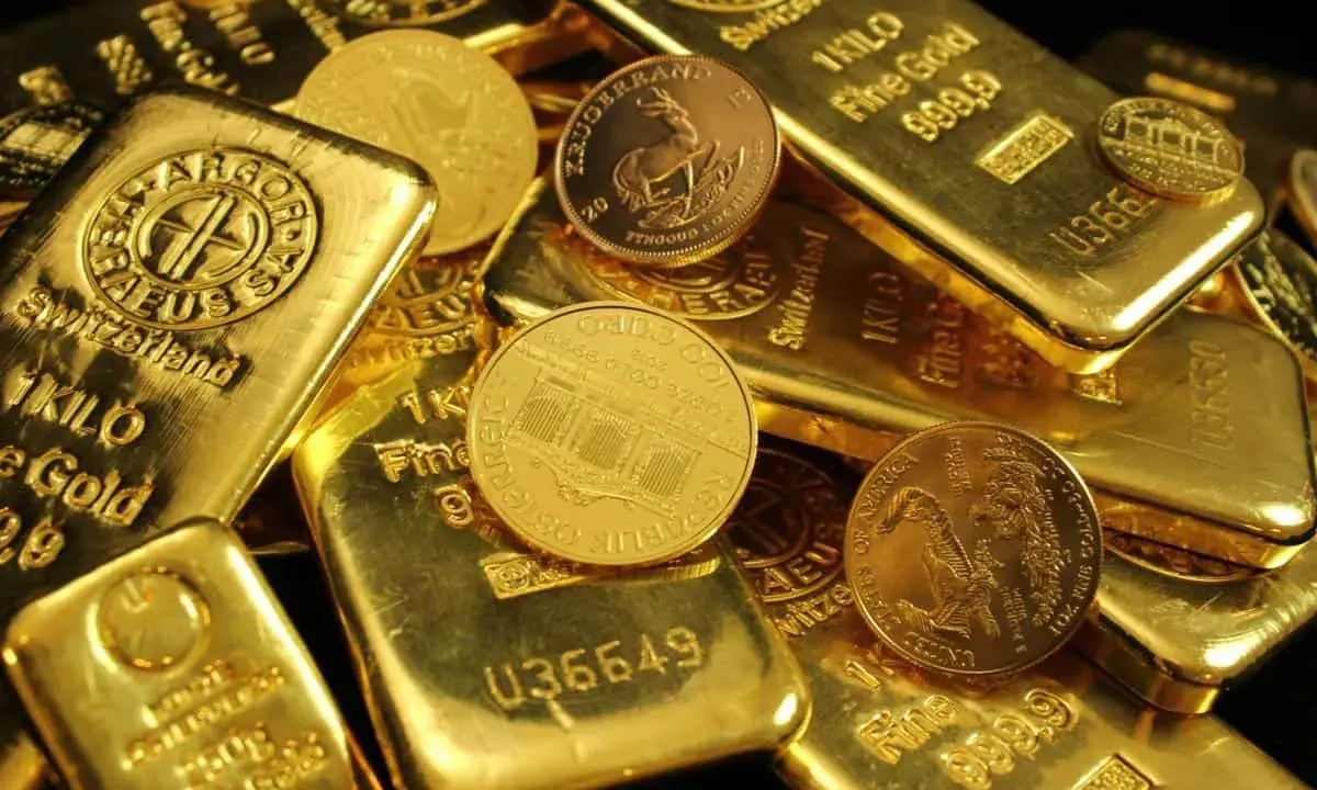 Złote sztabki i monety, niektóre z napisem "1 KILO Fine Gold".