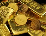Złote sztabki i monety, niektóre z napisem "1 KILO Fine Gold".