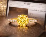 Złoty pierścionek z olśniewającym, żółtym diamentem na tle ekranu z napisem "Loose Yellow Diamond".