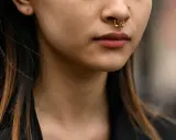 Złoty kolczyk do nosa z haczykiem, jak włożyć kolczyk do nosa z haczykiem, podkreśla usta.