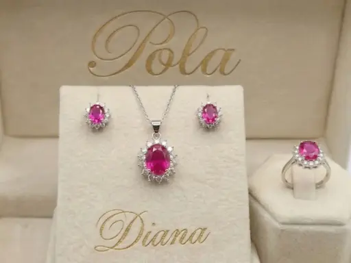 Elegancki komplet biżuterii z różowym korundem i białymi kamieniami, w tym kolczyki, naszyjnik i pierścionek, w beżowym pudełku z napisem "Diana".