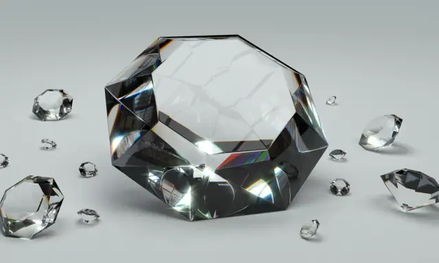Wielki, błyszczący diament otoczony mniejszymi kamieniami. To właśnie co to diament – symbol luksusu i piękna, odbijający światło.
