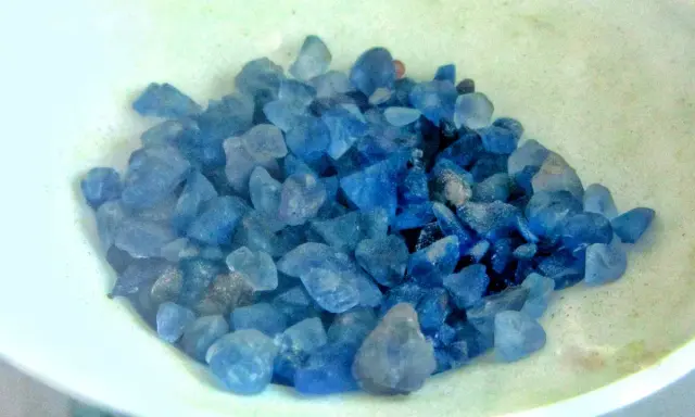 Grupka niebieskich kamieni, jakby gotowych na niebieski kamień w pierścionku, w jasnej miseczce.