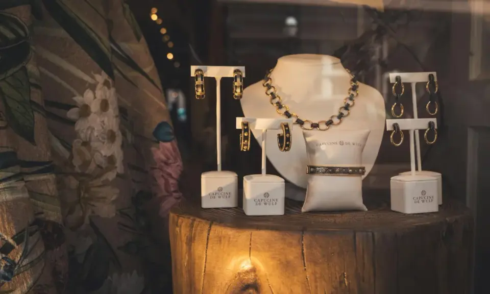 Elegancka biżuteria Capucine de Wulf. Złota bransoleta i kolczyki. Zastanawiasz się, ile kosztuje gram złota 14 karatowego?